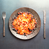 Hořící uhlíky naaranžované na železný talíř